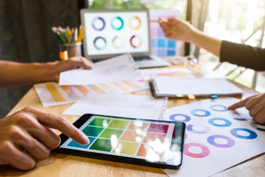 Consultanță design grafic cu palete de culori pe tabletă.